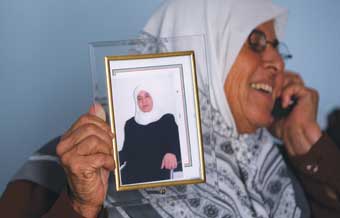 صورة لام فلسطينية تحمل صورة ابنتها الاسيرة 