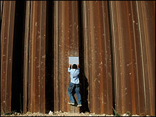 طفل فلسطيني يحاول النفاذ من فتحة الجدار على الحدود المصرية