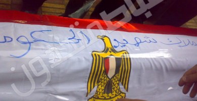 كتب المشيعون على علم مصر الملفوف بجثمان الفقيد "ملاك شهيد الحكومة"