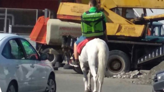 على ظهر حصان.. عامل روسي يوصل الطعام 