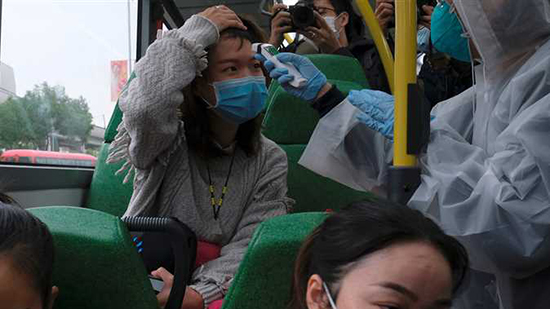 مواطنين صينيين يتطوعون لفحص درجة حرارة الركاب بعد اندلاع فيروس كورونا 