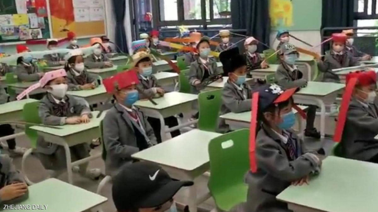 الطلاب ارتدوا قبعات بزوائد جانبية لتطبيق التباعد