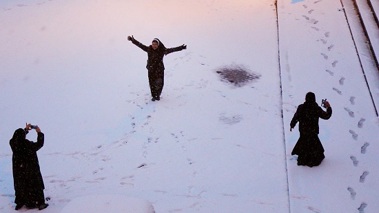 أهالي تبوك يستمتعون بتساقط الثلوج على جبل اللوز