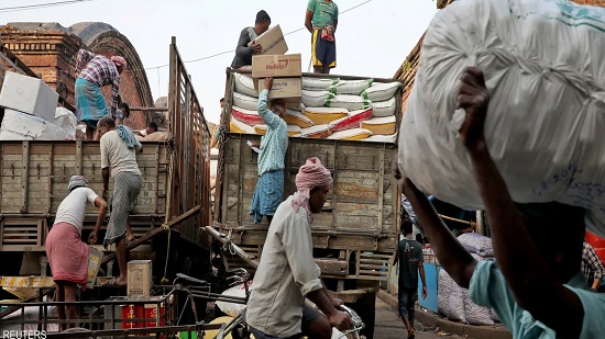 عمال يقومون بتحميل البضائع الاستهلاكية في كولكاتا - الهند