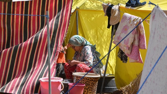 صورة مؤرخة في 16 سبتمبر 2023 لامرأة تجلس أمام خيمتها في أمزميز المغربية